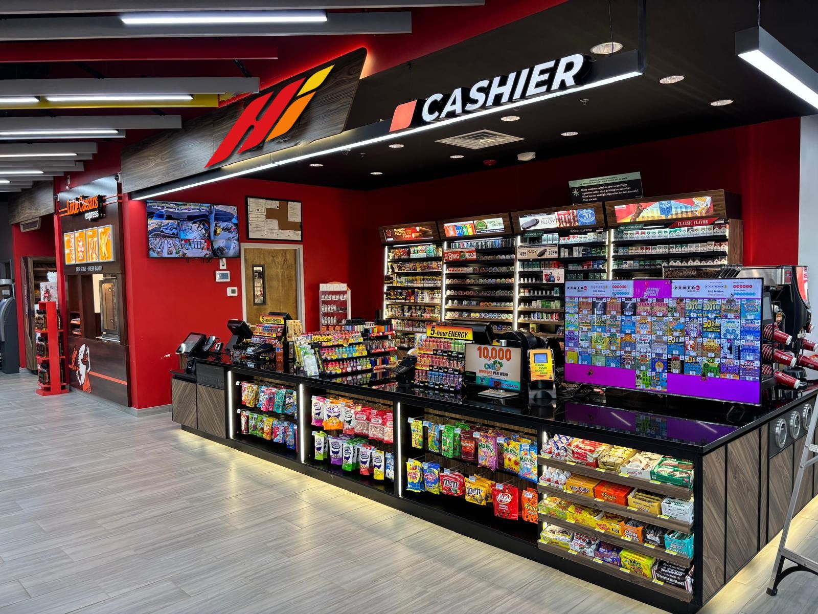 The cashier counter under the Hi monogram on the red wall