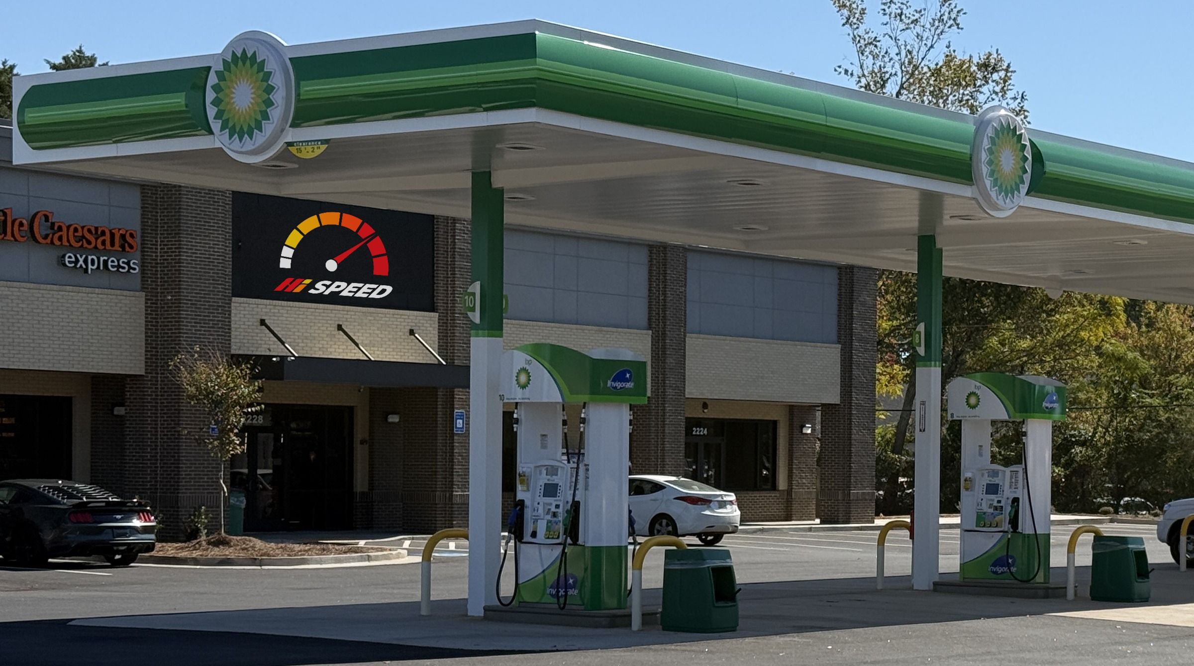 The forecourt: the Hi Speed sign on the store under the fuel canopy, with pumps in front